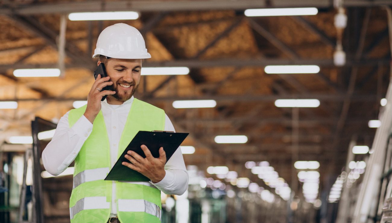 young man engineer working on factory making order on the phone